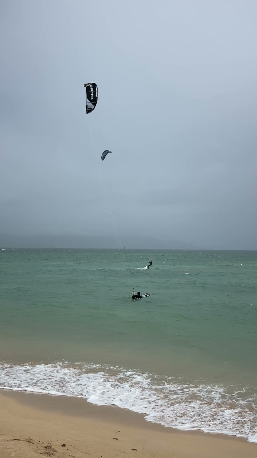 Tandem body drag near the shore, kite overhead, no board