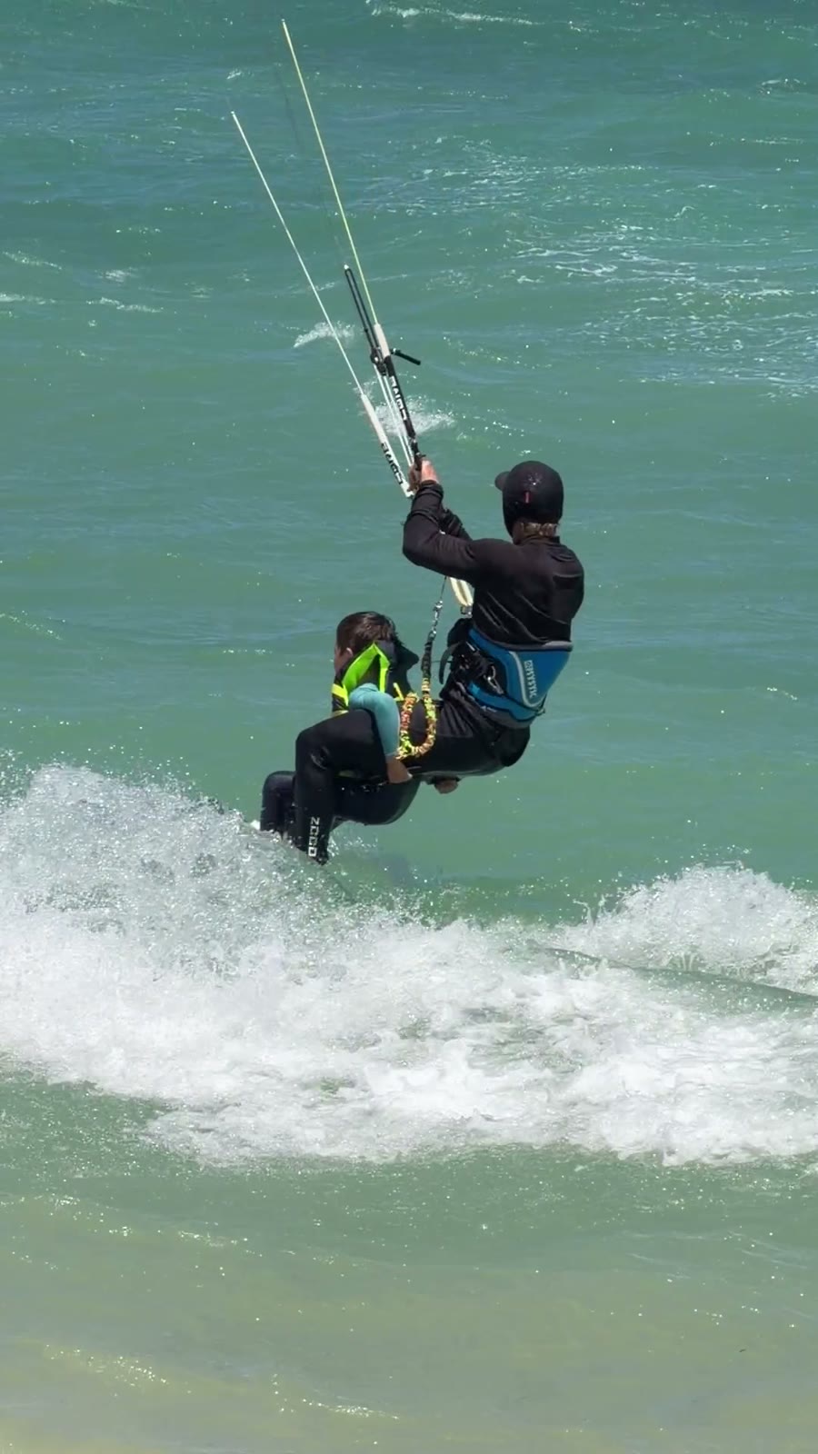 Popping off a wave tandem, board just clear of the water